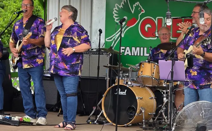 Ventura Band vocalist smiling at the microphone during a show