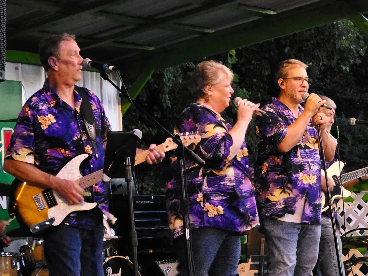 Ventura Band guitarist and vocalist on an indoor stage with blue curtains